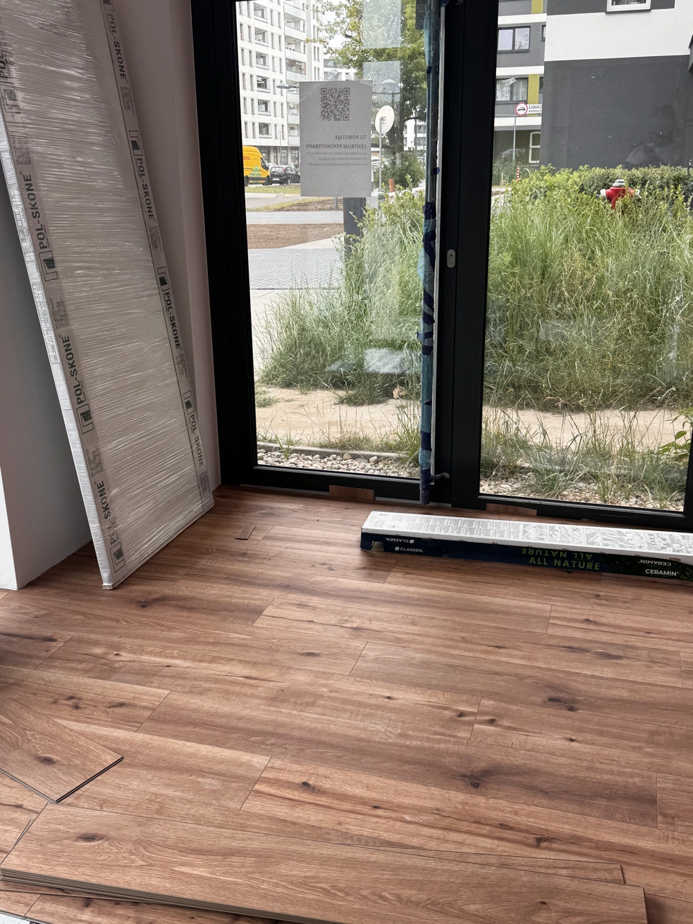 Innenraum mit frisch verlegtem Laminatboden und bodentiefen Fenstern als Beispiel für Laminat verlegen