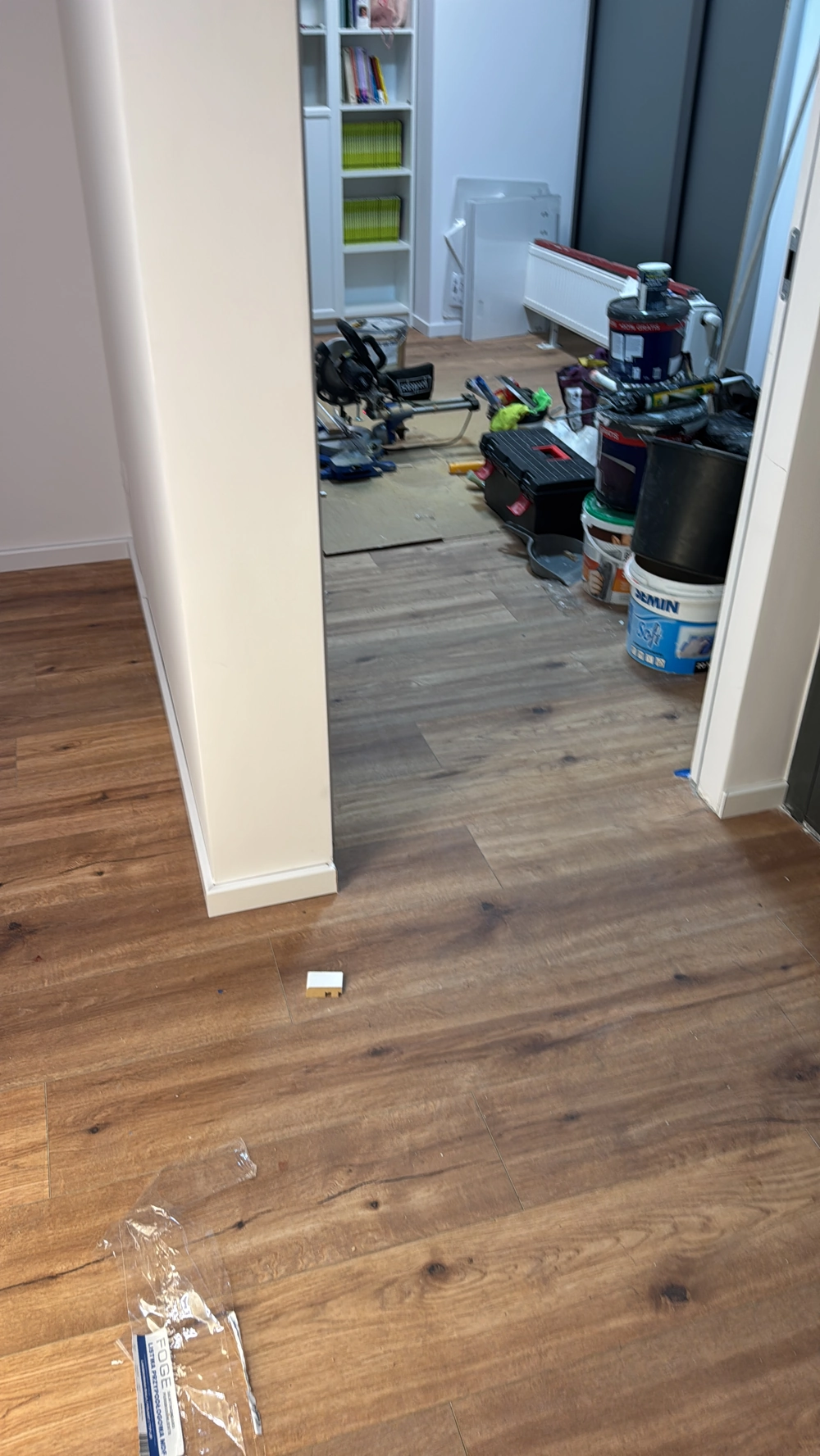 Laminat verlegen: neuer Boden zeigt fertig verlegtes Laminat in Raum mit Renovierungswerkzeugen