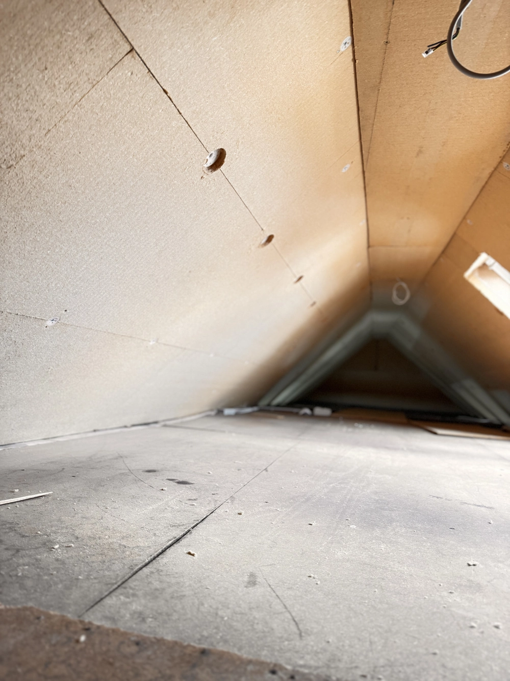 Rohes Dachgeschoss mit montierten Dämmplatten an den Dachschrägen im Rahmen des Dachgeschossausbaus