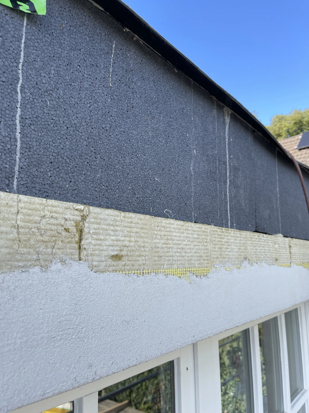 Fassadendämmung mit EPS- und Mineralwolleplatten an der Gebäudeaußenwand über Fenstern