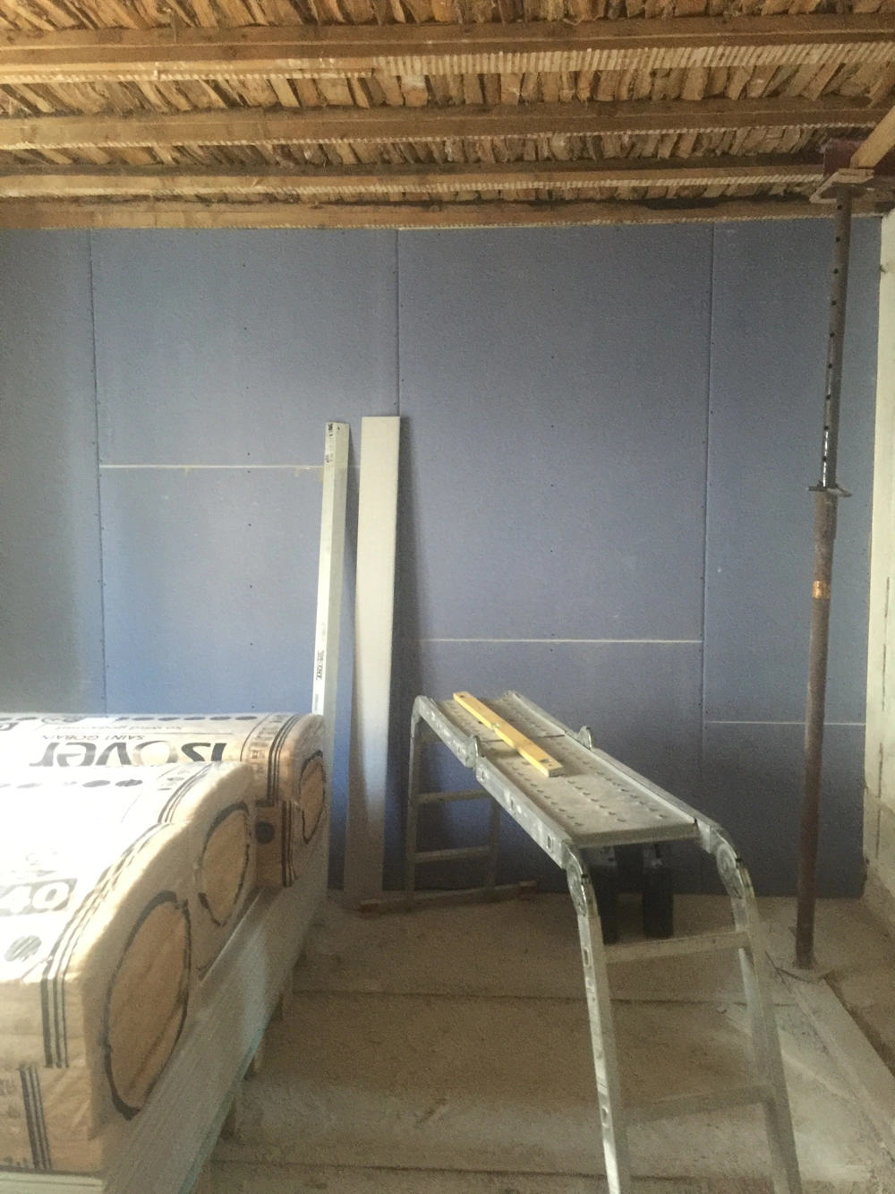 Trockenbau mit Gipskartonplatten, Dämmstoffpaketen und Montagegerüst in Rohbau