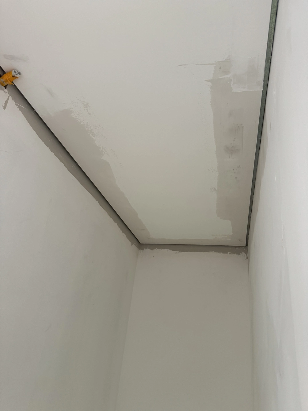 Unfertige abgehängte Decke mit Gipskartonplatten und Metallprofil im schmalen Raum, Abgehängte Decken