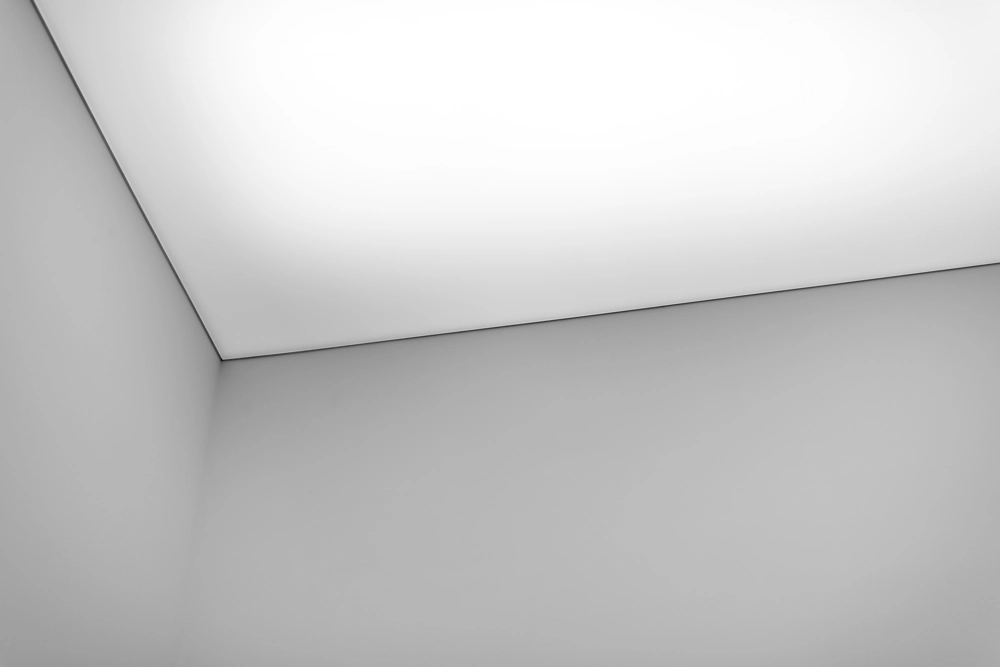 Abgehängte Decken in Zimmerecke mit glatten weißen Wänden