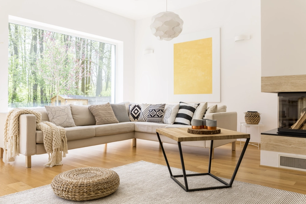 Modernes Wohnzimmer mit L-Sofa, Zierkissen, Webteppich, Holz-Couchtisch und frisch verlegtem Parkett verlegen