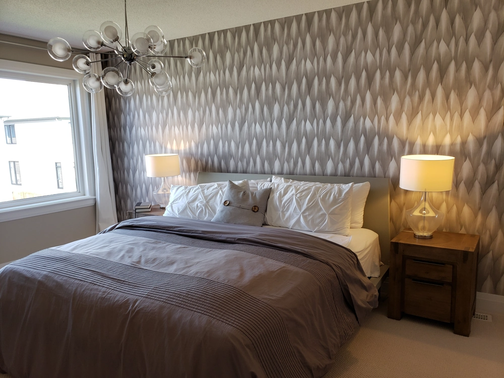 Modernes Schlafzimmer mit grauer gemusterter Designwand hinter dem Bett und Tapezierarbeiten an Wänden